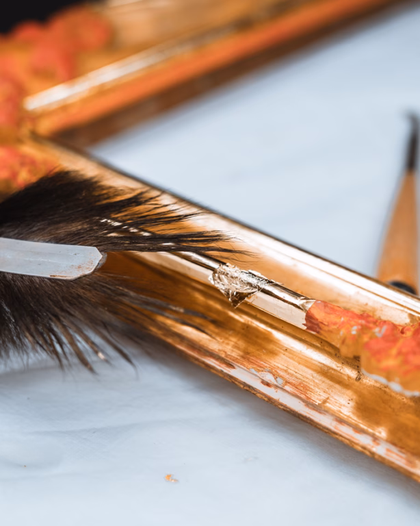 Platzierung eines Blattgoldes auf einen Bilderrahmen